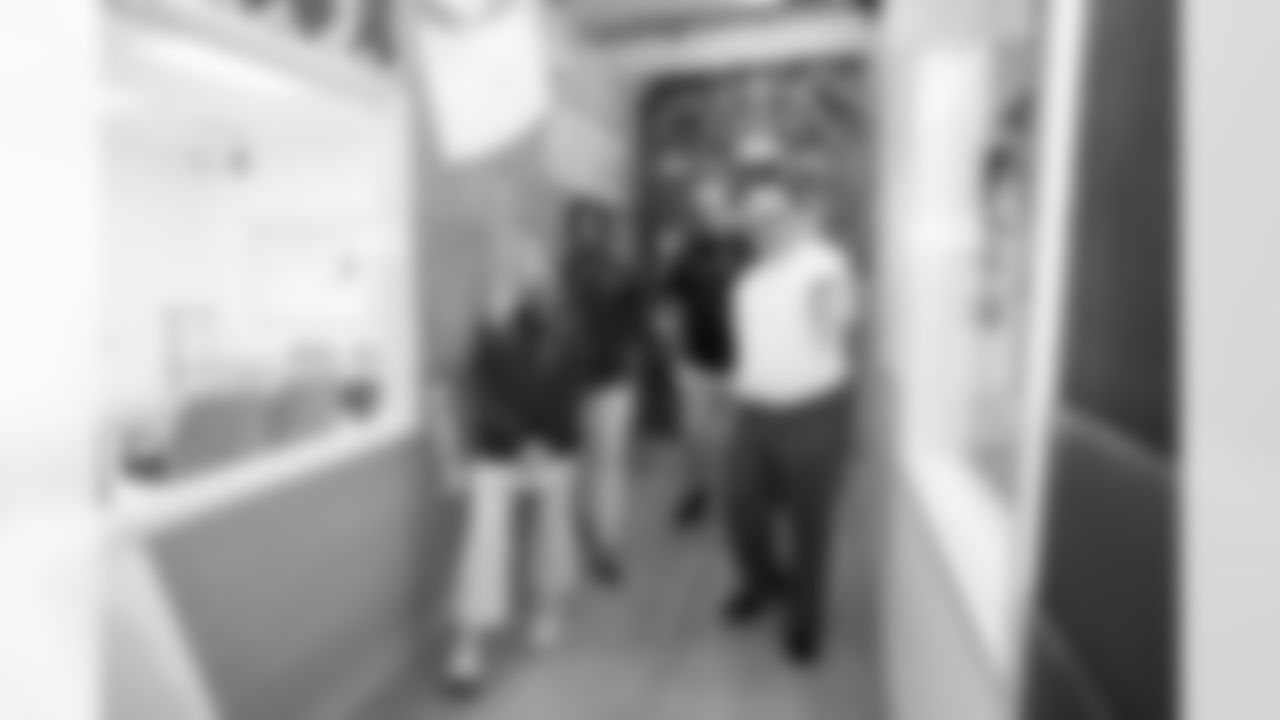 An inmate talks about his artwork with Carrie Walton Penner, Garett Bolles and Pat Bryant during a visit to the Arkansas Valley Correctional Facility in Ordway, Colorado on October 14, 2025. In partnership with the Vera Institute of Justice, the Denver Broncos Foundation toured ChangeMakers Village (a Restoring Promise Unit).Photo by Gabriel Christus / Denver Broncos