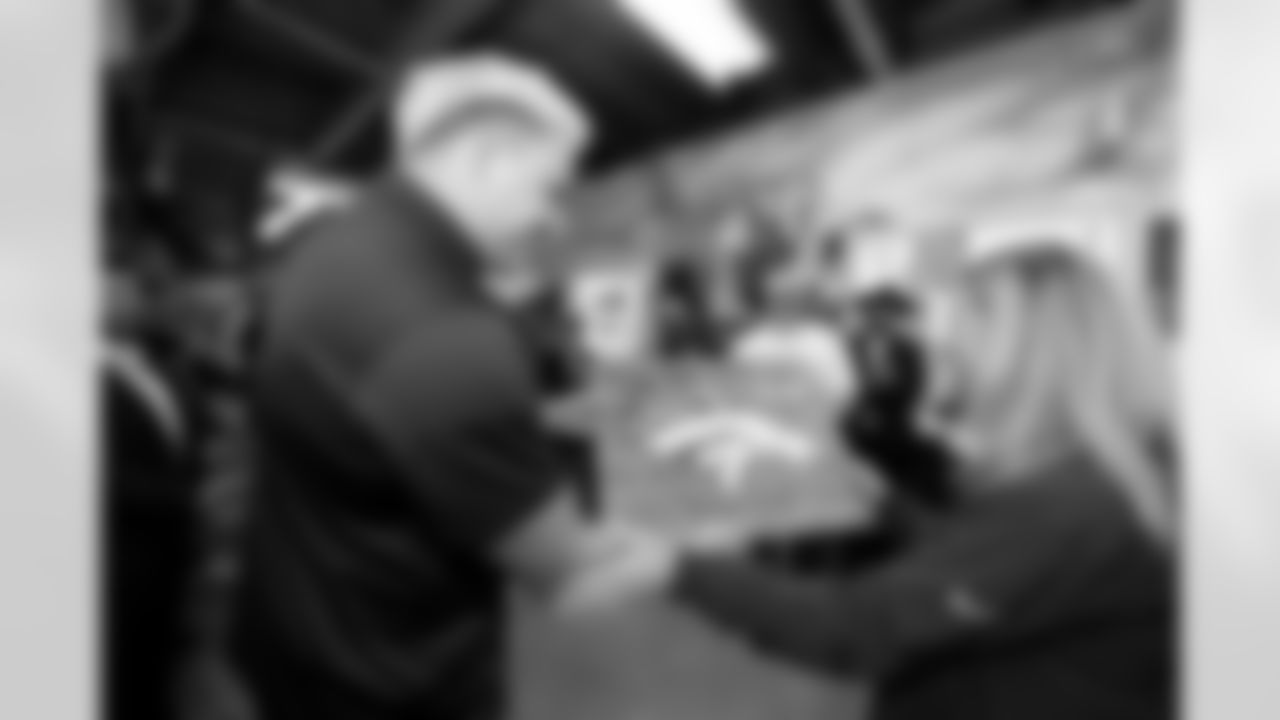 An inmate gives a piece of artwork to the Denver Broncos during a visit to the Arkansas Valley Correctional Facility in Ordway, Colorado on October 14, 2025. In partnership with the Vera Institute of Justice, the Denver Broncos Foundation toured ChangeMakers Village (a Restoring Promise Unit).Photo by Gabriel Christus / Denver Broncos