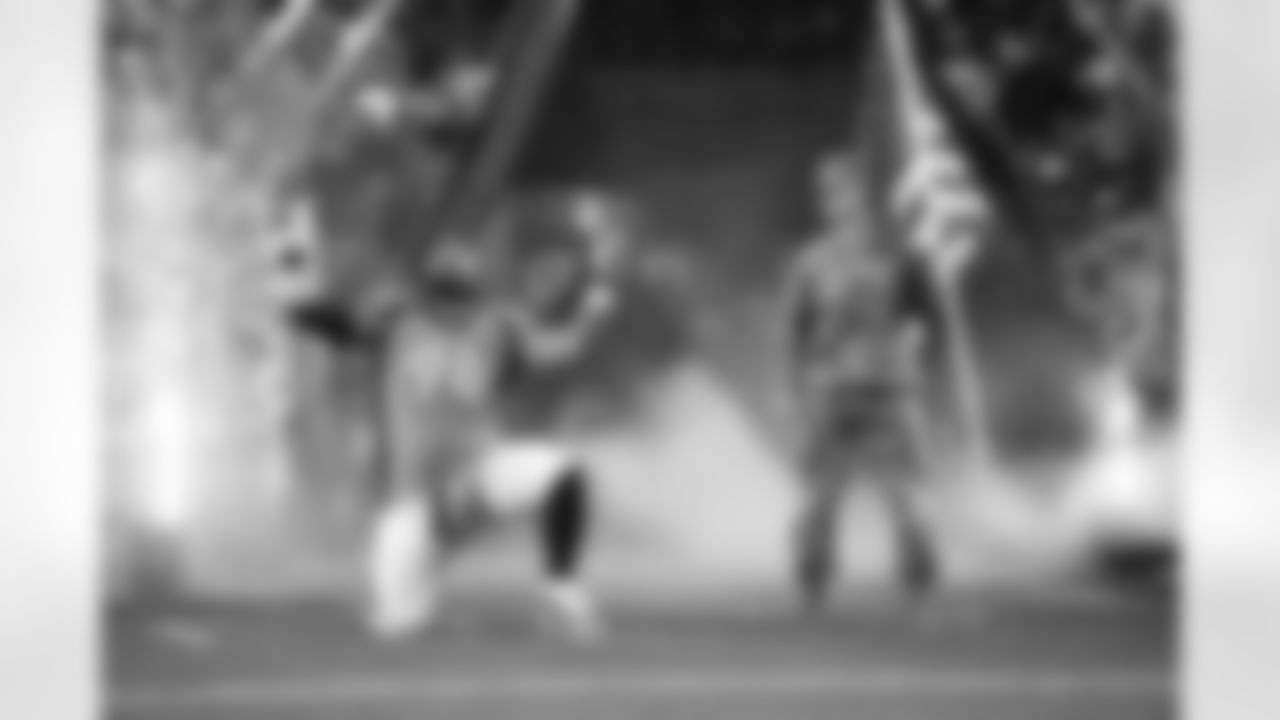 Denver Broncos nose tackle Domata Peko Sr. (94) enters the field with a soldier for the Salute to Service recognition during player introductions prior to action against the New England Patriots in the NFL game at Sports Authority Field in Denver, Colo. November 12, 2017.