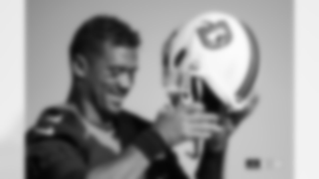 Russell Wilson smiles as he puts on his "Snowcapped" alternate white helmet during practice at Centura Health Training Center in Englewood, Colorado on December 21, 2023. Photo by Ben Swanson / Denver Broncos
