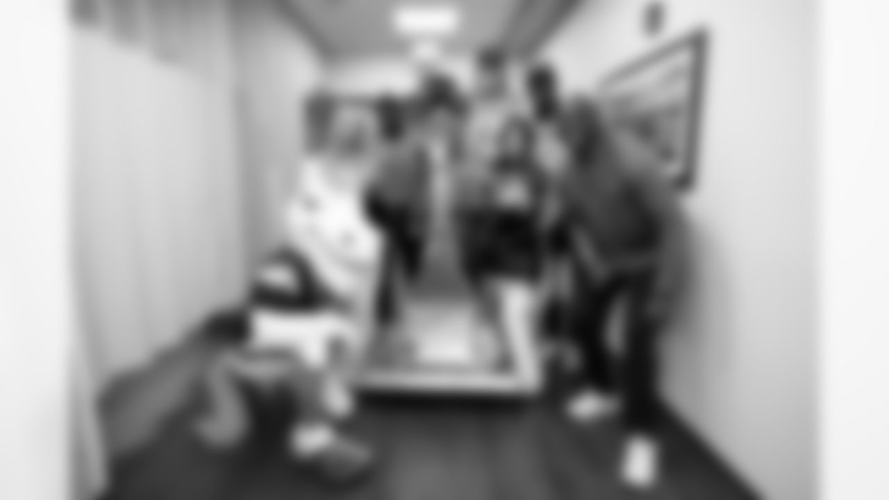 Miles the Mascot, DBC Sydney J, Montee Ball, Frank Crum, Que Robinson, DBC Julia and Reuben Droughns pose with the Fight Like A Bronco bell during a visit to CommonSpirit's St. Anthony Hospital in Lakewood, Colorado on October 21, 2025. Photo by Ben Swanson / Denver Broncos
