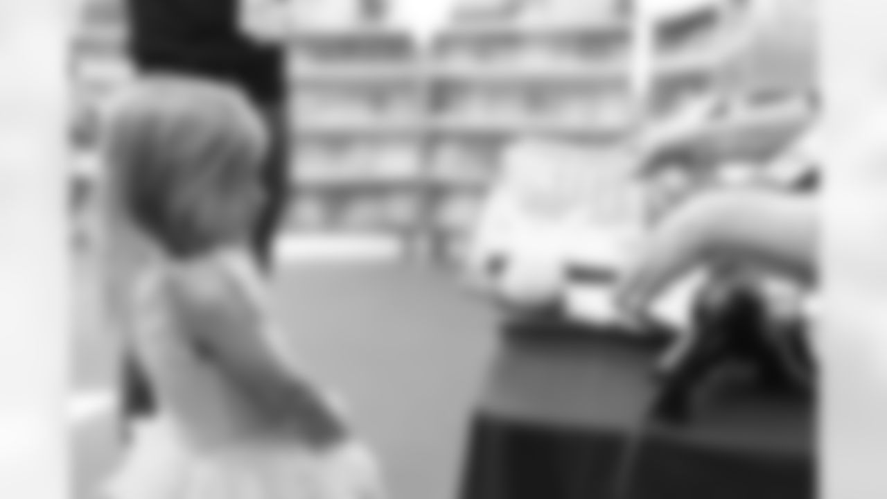 A kid checks out with her book selections during a book fair at Greenlee Elementary School in Denver, Colorado on April 10, 2024. Photo by Gabriel Christus / Denver Broncos