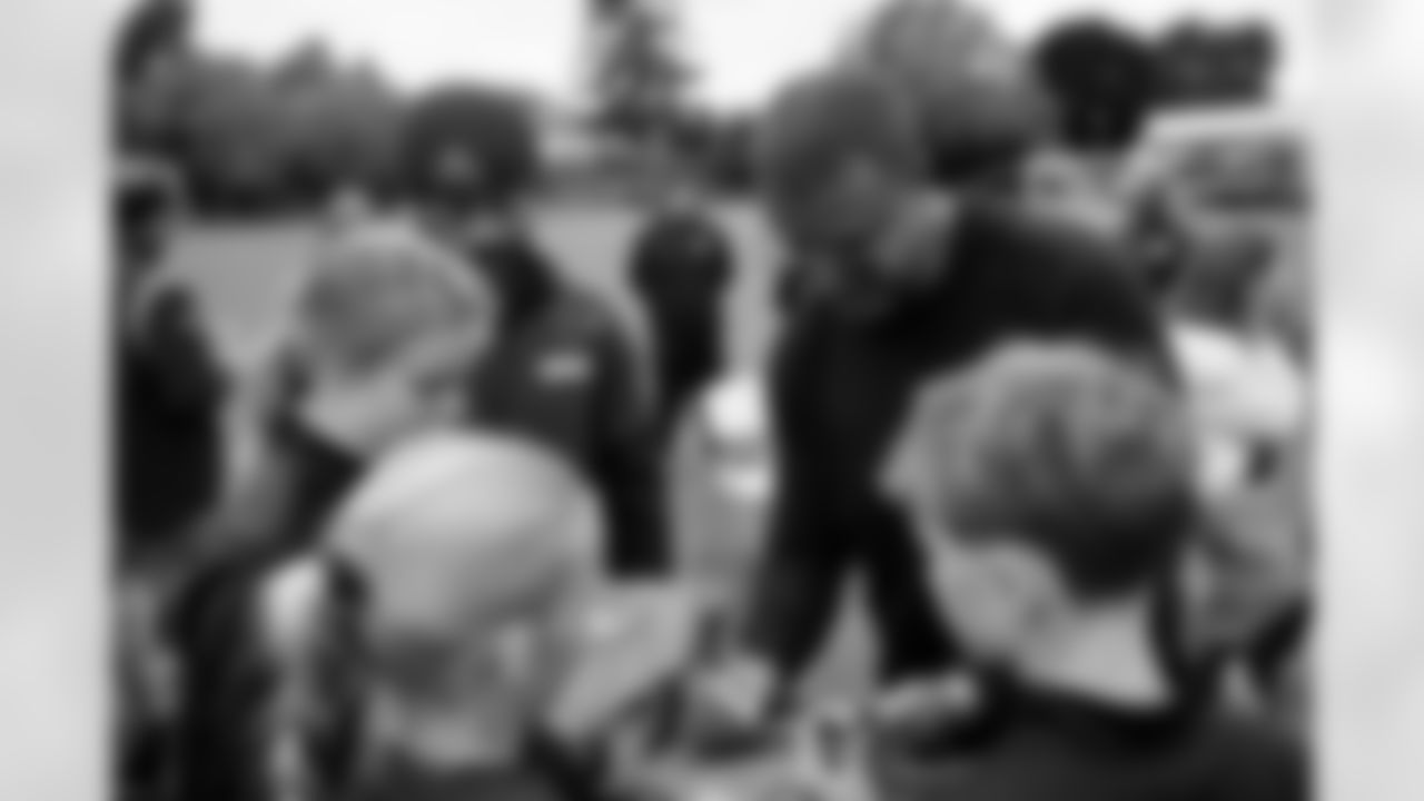 Steve Atwater autographs gift bags at the Denver Broncos flag football clinic at Grey Court School in Richmond, England on October 9, 2025. Photo by Ben Swanson / Denver Broncos
