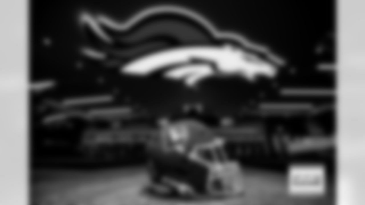 A throwback helmet rests on the ground beneath a modern Broncos' logo before the Broncos' Week 5 game against the Las Vegas Raiders at Empower Field at Mile High in Denver, Colorado on October 6, 2024. Photo by Ben Swanson / Denver Broncos