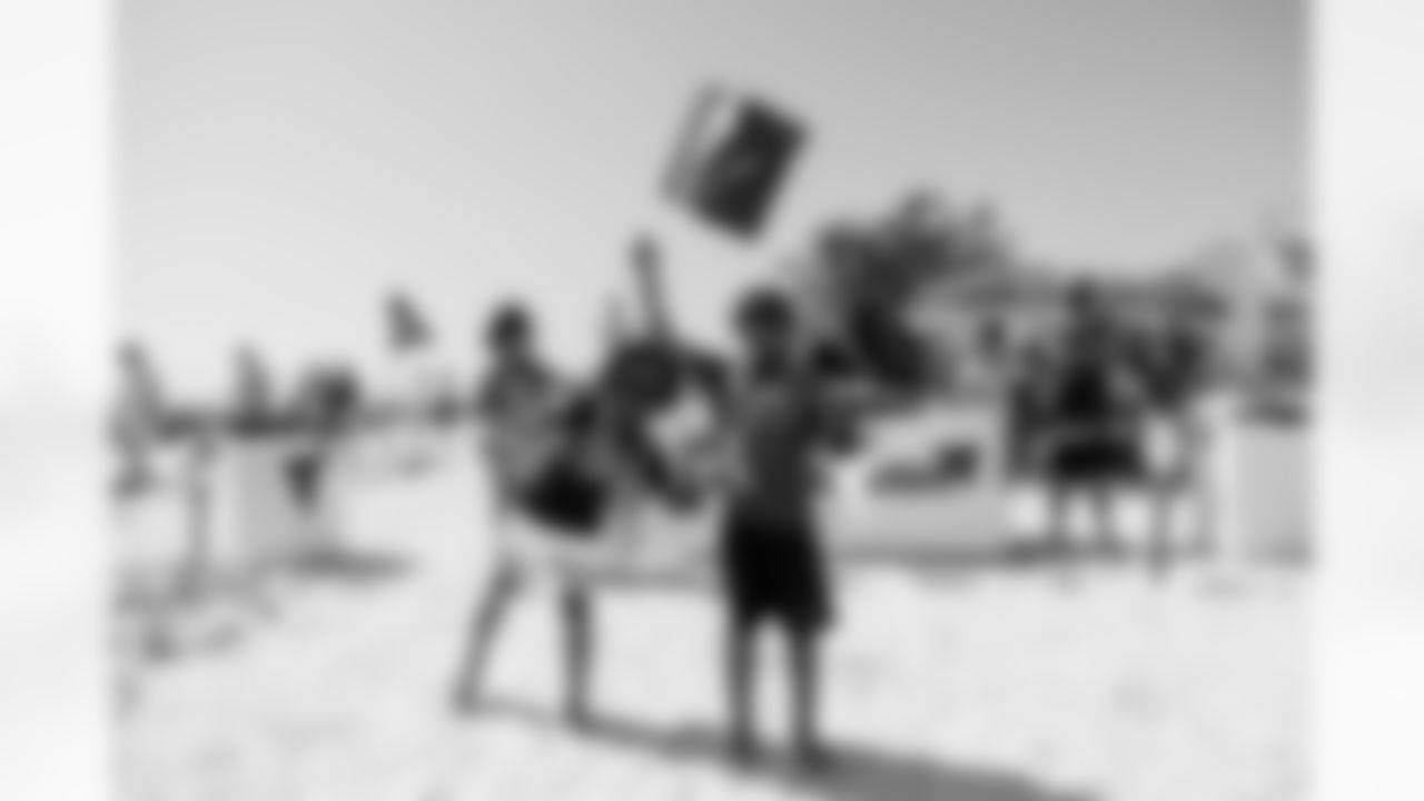 ST. PETE BEACH, FL - April 26, 2025 - Kids wave flags during Bucs Beach Bash. Photo By Dave Pullis/Tampa Bay Buccaneers