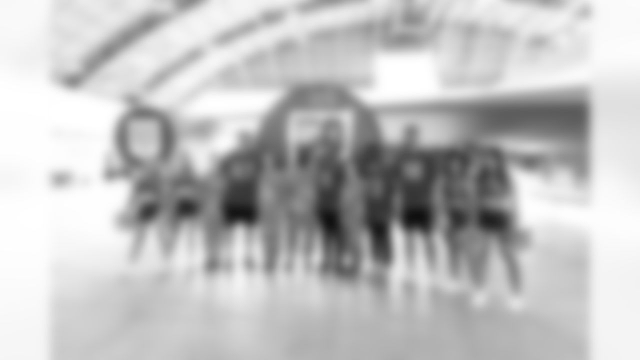 TAMPA, FL - December 02, 2025 - Tampa Bay Buccaneers Cheerleaders, Guard Luke Goedeke #67, Inside Linebacker SirVocea Dennis #8, Safety Tykee Smith #23, and Outside Linebacker Anthony Nelson #98 of the Tampa Bay Buccaneers during a visit to MacDill Air Force Base. Photo By Kyle Zedaker/Tampa Bay Buccaneers