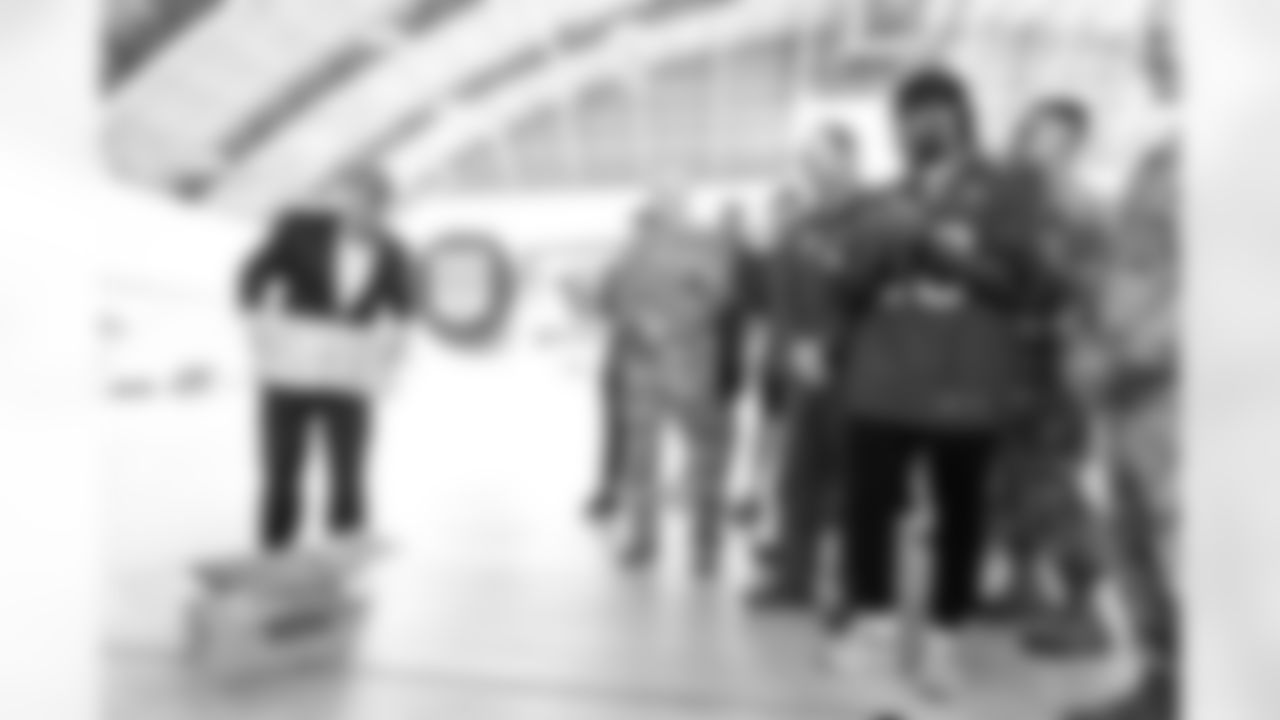 TAMPA, FL - December 02, 2025 - Brian Ford, the Buccaneers Salute to Service Nominee, receives a gift during a visit to MacDill Air Force Base. Photo By Kyle Zedaker/Tampa Bay Buccaneers