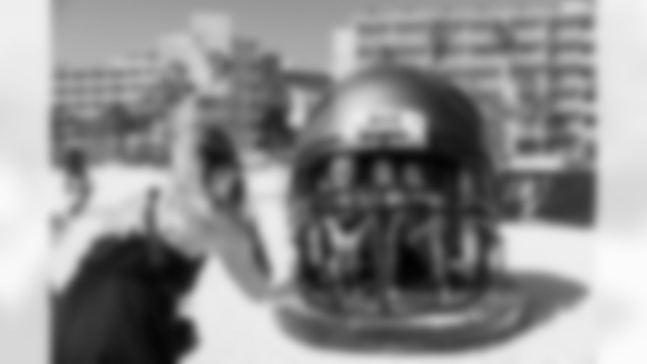 ST. PETE BEACH, FL - April 26, 2025 - Attendees take photos in the giant helmet during Bucs Beach Bash. Photo By Dave Pullis/Tampa Bay Buccaneers