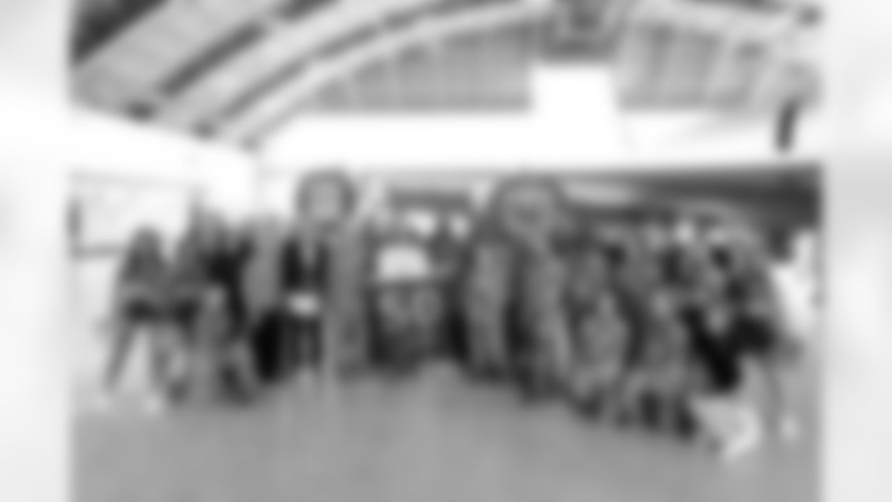 TAMPA, FL - December 02, 2025 - Tampa Bay Buccaneers Cheerleaders, Brian Ford, Outside Linebacker Anthony Nelson #98, Inside Linebacker SirVocea Dennis #8, Safety Tykee Smith #23, and Guard Luke Goedeke #67 of the Tampa Bay Buccaneers with military members and staff during a visit to MacDill Air Force Base. Photo By Kyle Zedaker/Tampa Bay Buccaneers