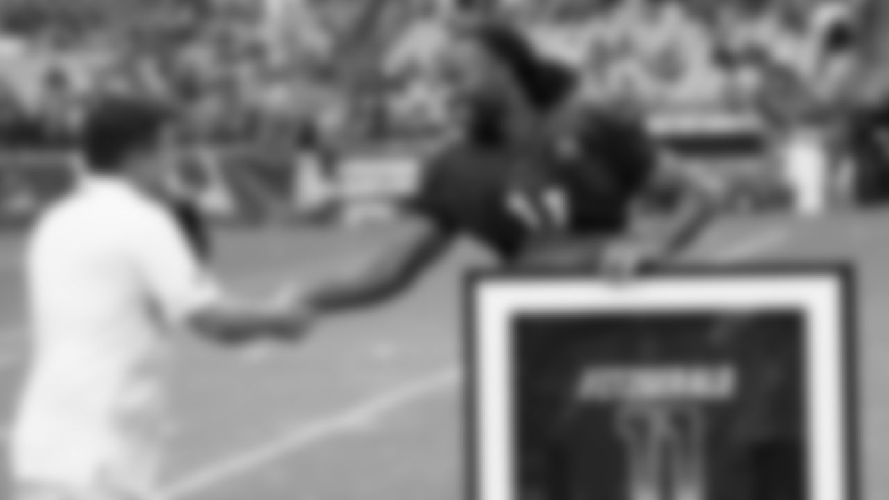Larry Fitzgerald (11) shakes hands with Cardinals owner Michael Bidwill as Fitzgerald gets his framed Pro Bowl jersey before a training camp practice in 2018.