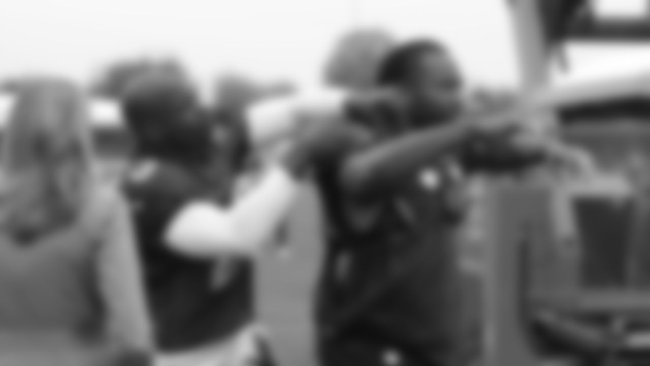 Larry Fitzgerald gets jersey help from teammate Adrian Peterson before a London practice in 2017.