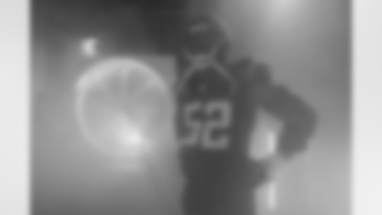 Blending Colors - Khalil Mack runs out last in home games where the defense is introduced, so as others were running out, I moved to the back of the tunnel where he was shrouded in the smoke that is pumped out for the intros. The pulsing light tubes had lit up gold against the team's Navy Super Chargers uniforms, and the fan in the background has the team's primary powder blue, making a good color contrast.