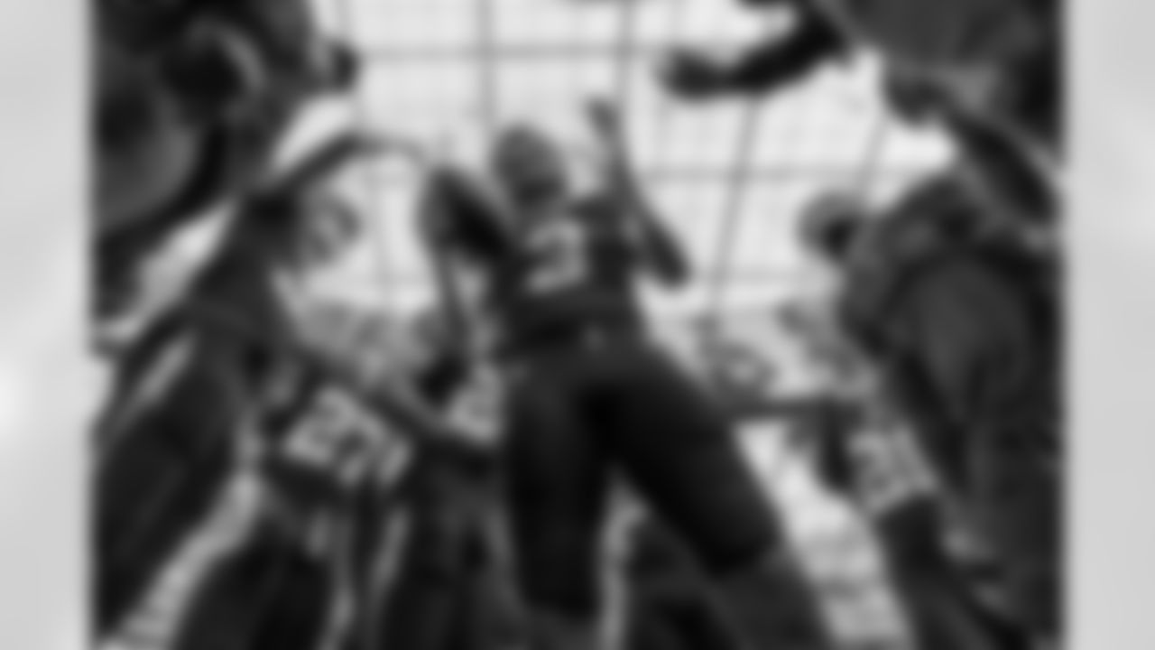 Bringing the Juice - It's not the typical Derwin pregame huddle shot with the full team, but during the defensive back huddle. The low angle gives a unique perspective as he looks down and pounds the football, bringing the energy. It gives you a sense of being in the middle of the action and shows the unique roof at SoFi as well.