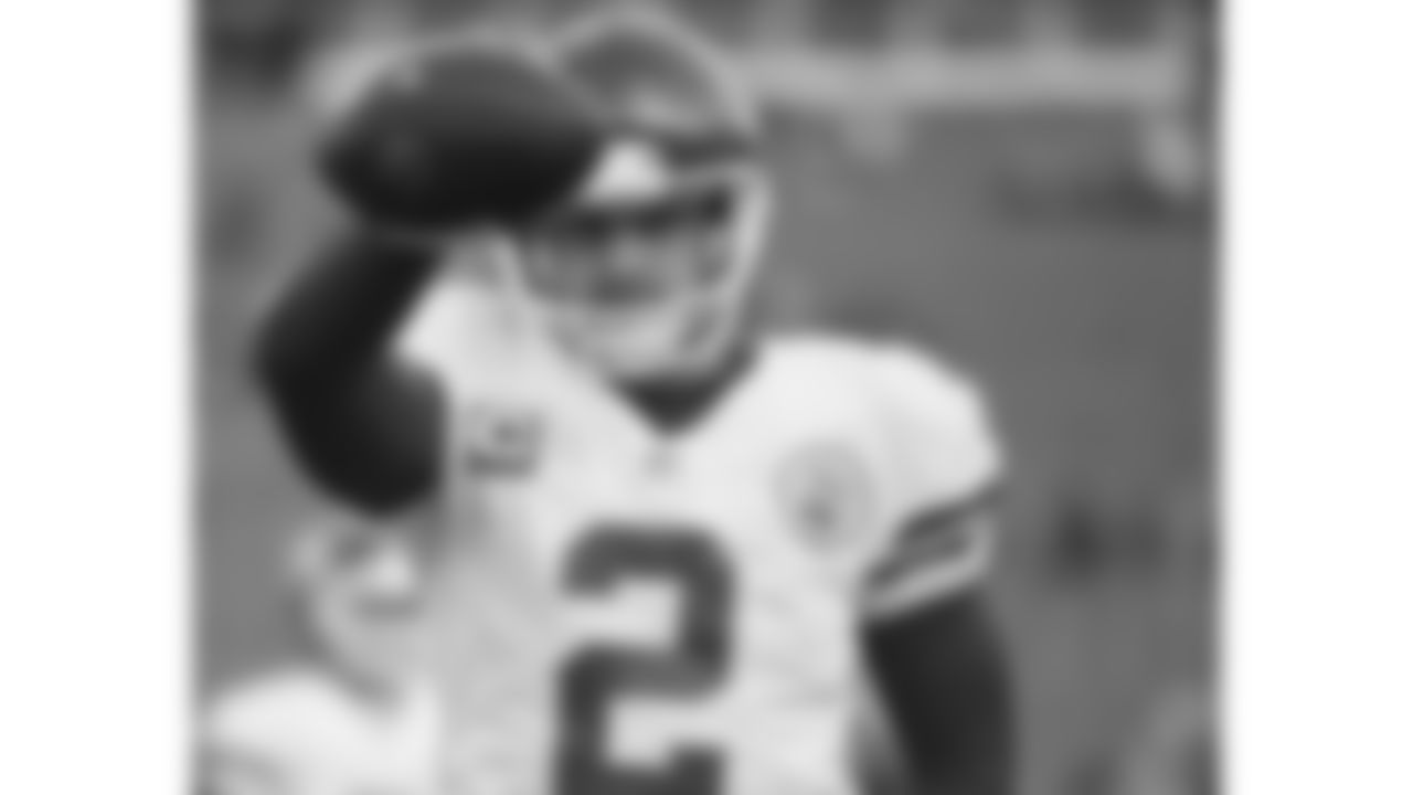 Kansas City Chiefs punter Dustin Colquitt (2) holds a football up and points out to a teammate.