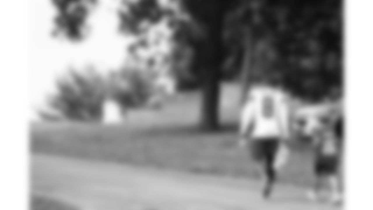 Kansas City Chiefs cornerback Kristian Fulton (8) walks up the hill with a fan after Day 1 of training camp practice on Tuesday, July 22, 2025.