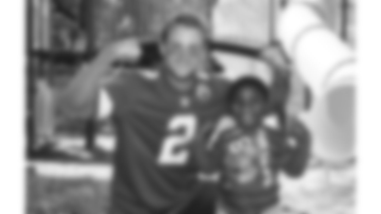 Kansas City Chiefs punter Dustin Colquitt (2) poses with a young fan during a 2014 community event at a playground.
