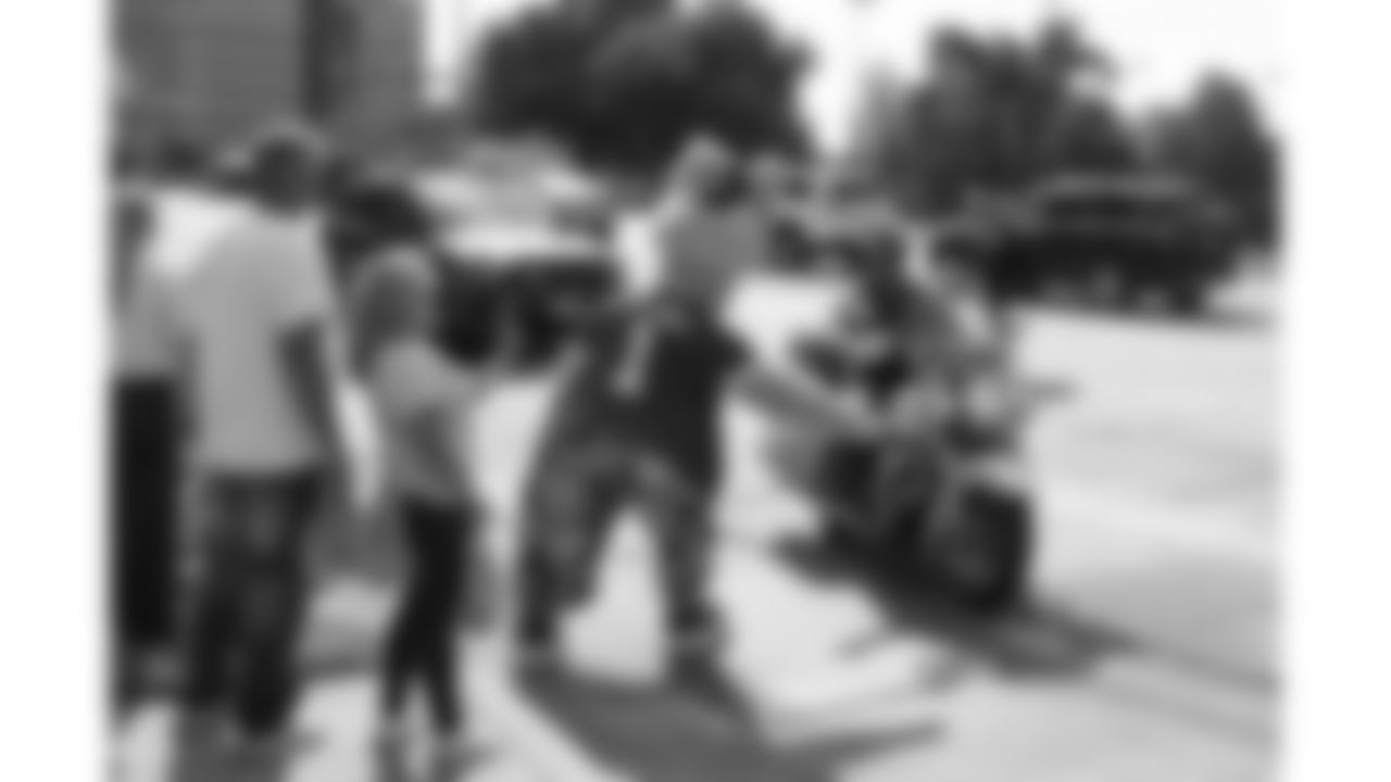 KC Wolf high fives police officers arriving at the Bradens Hope Hero Parade event on Friday, August 29, 2025 at Mill Creek Park in Kansas City, MO.