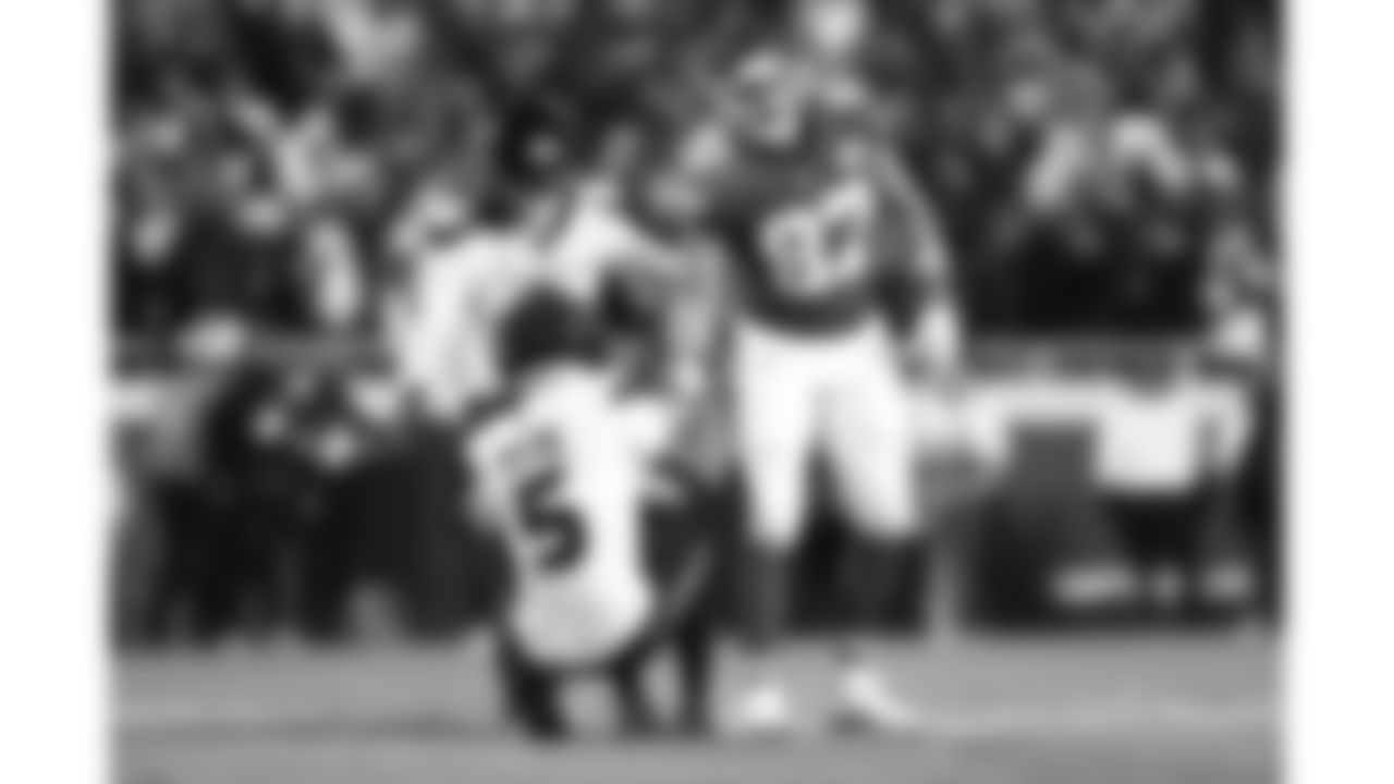 Kansas City Chiefs tight end Travis Kelce (87) helps Houston Texans safety Jalen Pitre (5) up during a week 14 NFL football game, Sunday, December 7, 2025 in Kansas City, MO.