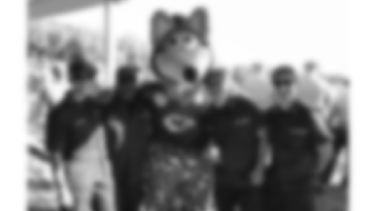 KC wolf poses with U.S. service members attending Military Appreciation Day during day 17 of Training Camp practice on Wednesday, August 13, 2025.