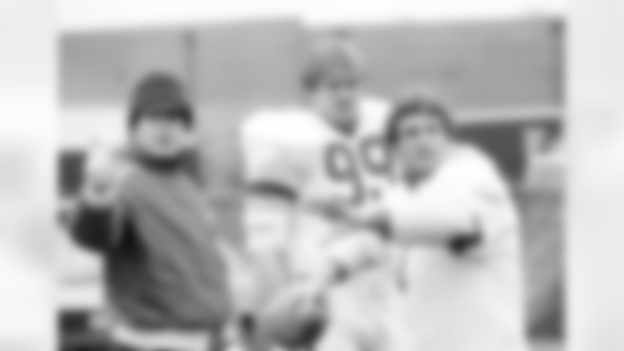 John Riggins, running back for the Washington Redskins, left, and offensive lineman, Joe Jacoby, center, look on as an unidentified teammate gets ready to launch the ball, during a workout at Redskins Park in Chantilly, Va., Jan. 6, 1984. The offensive line for the Redskins, of which John Riggins has been made an honorary member, is nicknamed the "Hogs". The Washington Redskins will play the San Francisco 49ers this Sunday for the NFC title game at RFK Stadium. (AP Photo/Ron Edmonds)