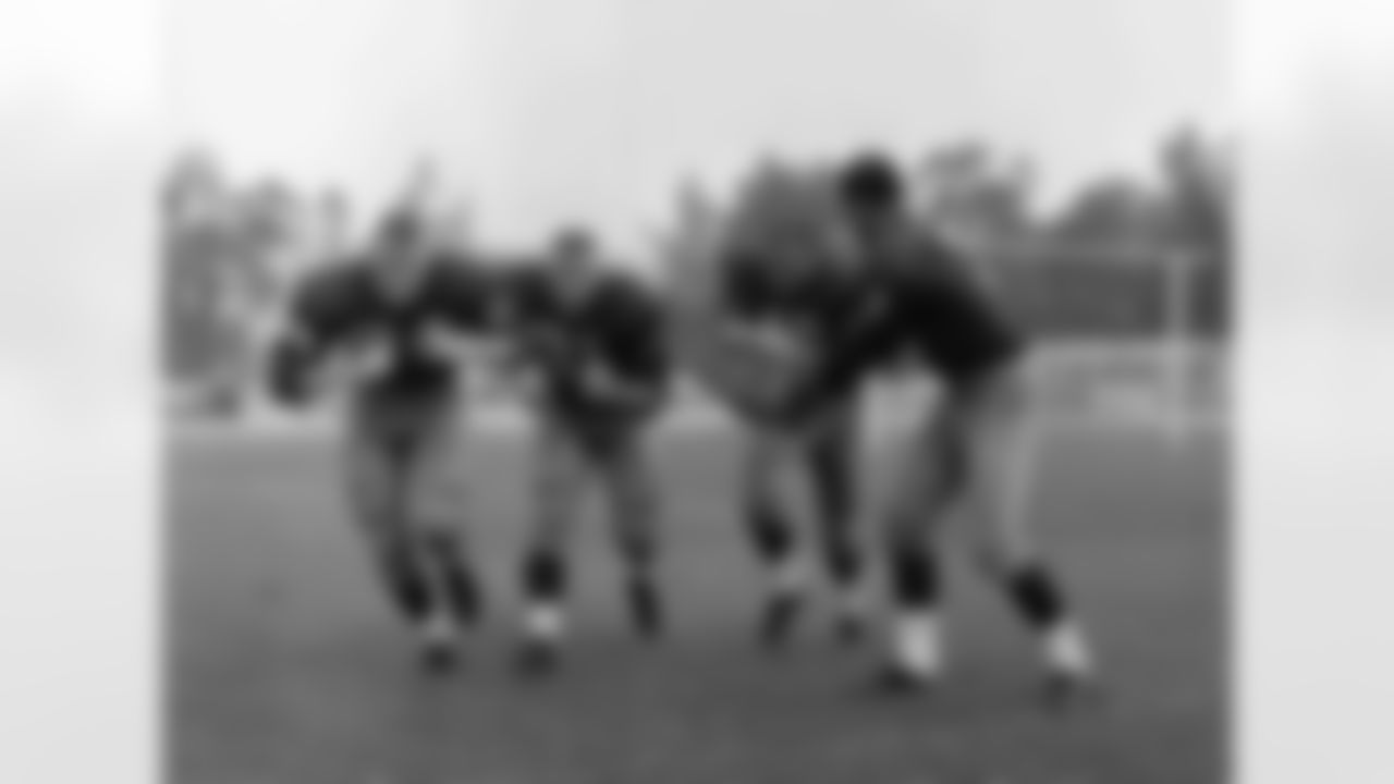 ADVANCE FOR WEEKEND, AUG. 10-11 - FILE - In this Juy 1961 file photo, Washington Redskins quarterback Ralph Guglielmi hands off to Dick James at the NFL football team's training camp at Occidental College in Los Angeles. Tom Osborne is at left, and Don Besseler is next to him. Teams holding training camp away from home date to the early days of the NFL in the 1920s. The Redskins spent 23 years on the West Coast starting in 1939, including the final 16 at Occidental College. (AP Photo/File)