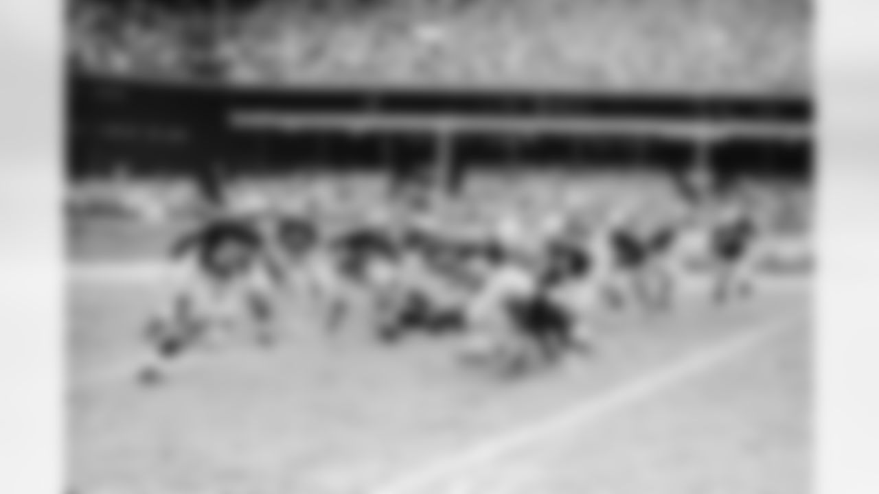 Bill Dudley, Washington Redskins halfback, appears to be blocked but carried on for a 12-yard gain in the first quarter on this right end play in Pittsburgh, Nov. 18, 1951. Dudley was a thorn in the side of the Pittsburgh Steelers all afternoon as he kicked three field goals to help the Redskins defeat the Steelers, 22-7. (AP Photo/Walter Stein)