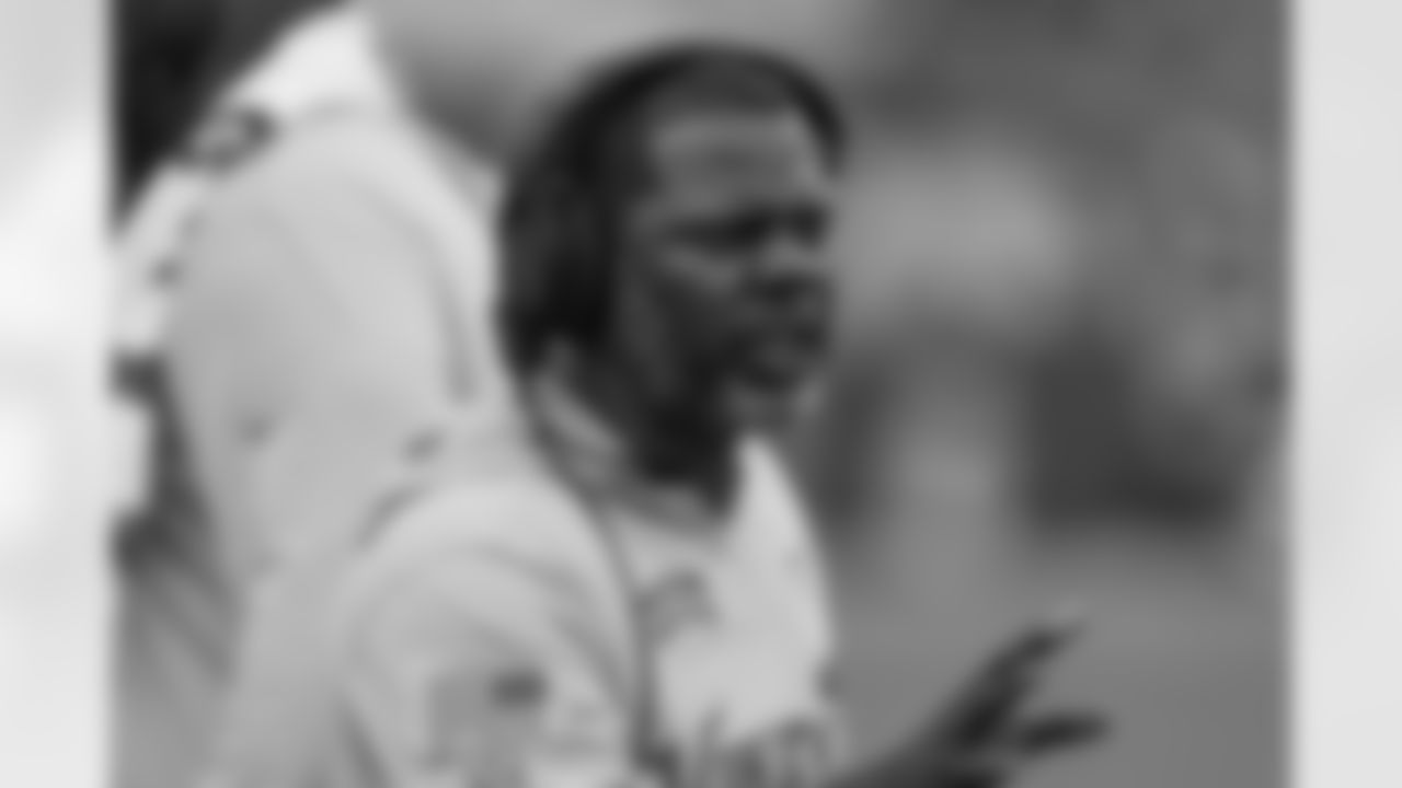 Minnesota Vikings passing game coordinator/defensive backs coach Daronte Jones speaks with a player while wearing a "Salute to Service" shirt during an NFL football game against the Jacksonville Jaguars, Sunday, Nov. 10, 2024, in Jacksonville, Fla. The Vikings defeated the Jaguars 12-7. (AP Photo/Gary McCullough)