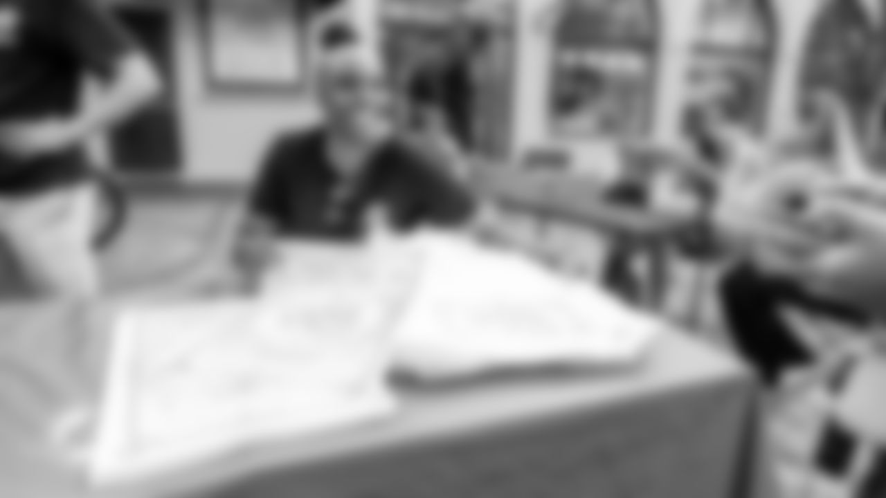 A worker hands out Celebrate the 305 posters and tote bags.