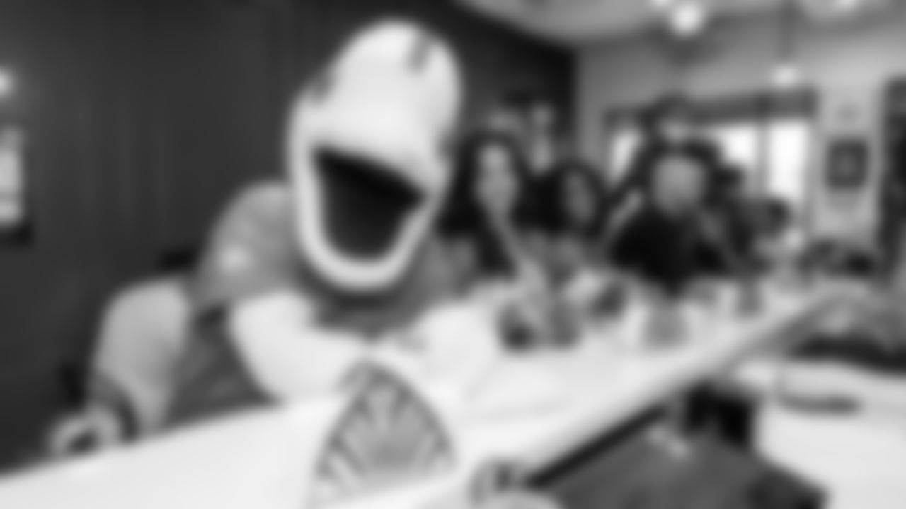 TD and cheerleaders smile at the bar waiting for a sandwich at Sanguich.