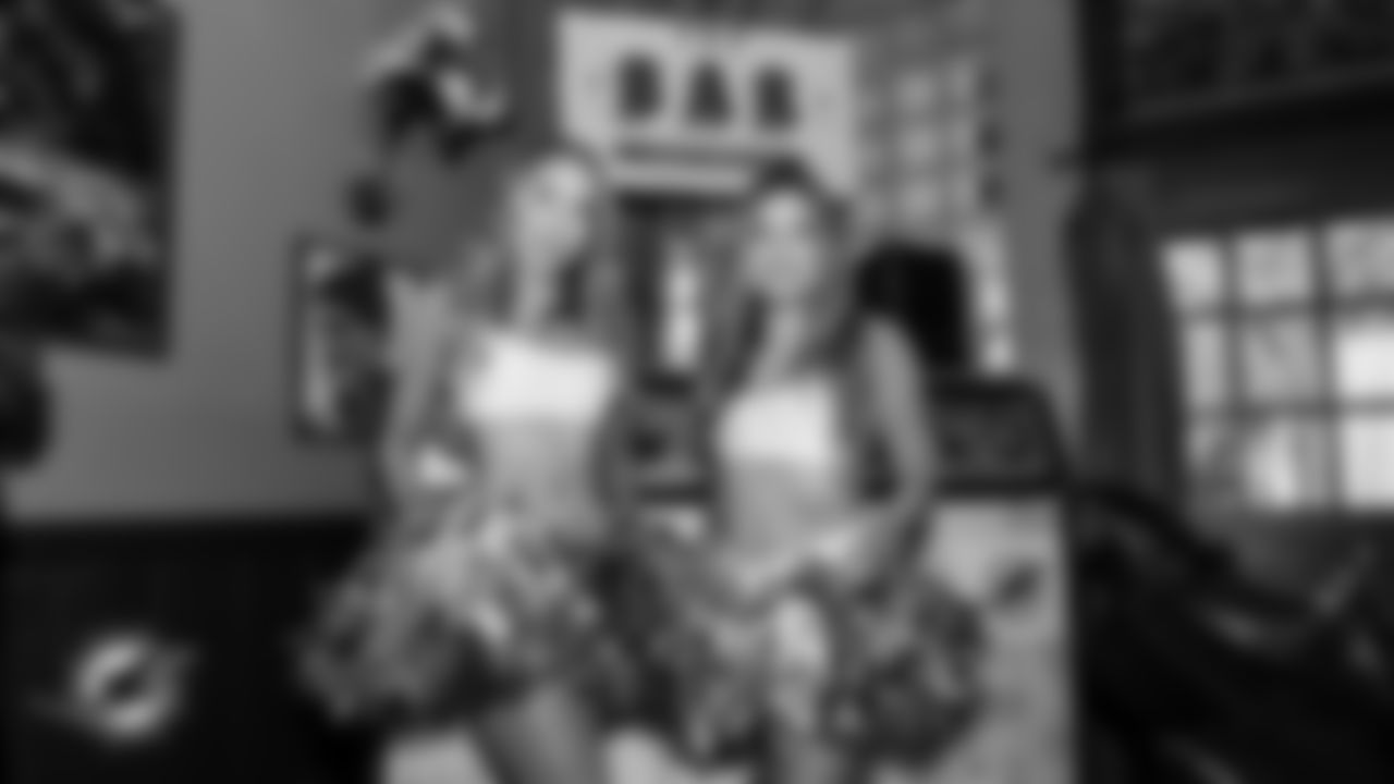 Cheerleaders pose in front of the DJ booth at The Bar.