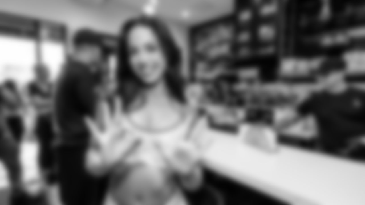 A cheerleader holds up the iconic 305 sign with her hands.