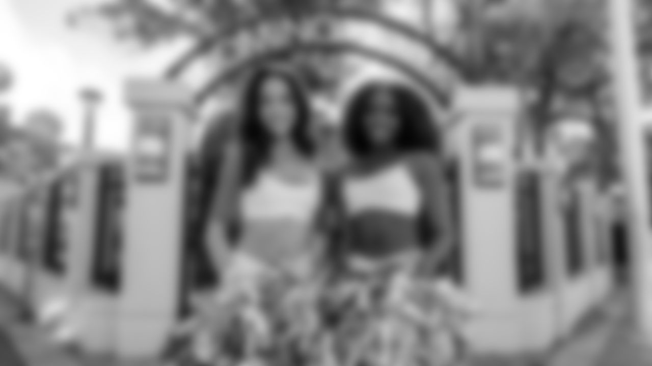 Cheerleaders pose in front of Domino Park.