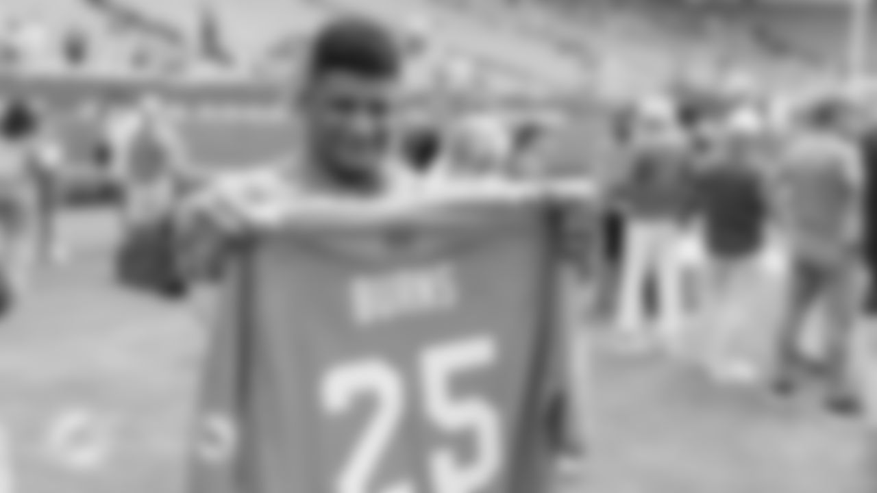 Brazilian mixed martial artist Gilbert Burns holds up a Miami Dolphins jersey before an NFL football game against the Buffalo Bills on Sunday, Nov. 9, 2025 in Miami Gardens, Fla. (Tomas Diniz Santos/Miami Dolphins via AP)