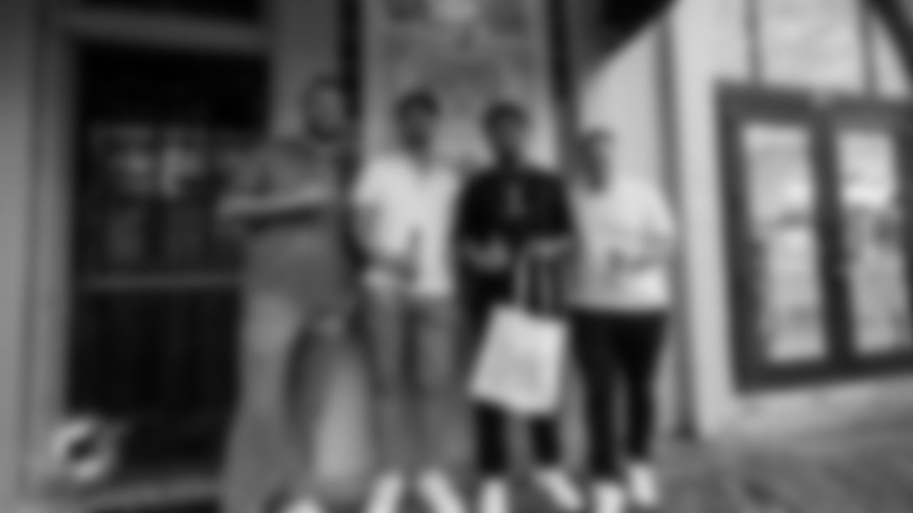 Fans gather outside The Bar with a Celebrate the 305 tote bag.