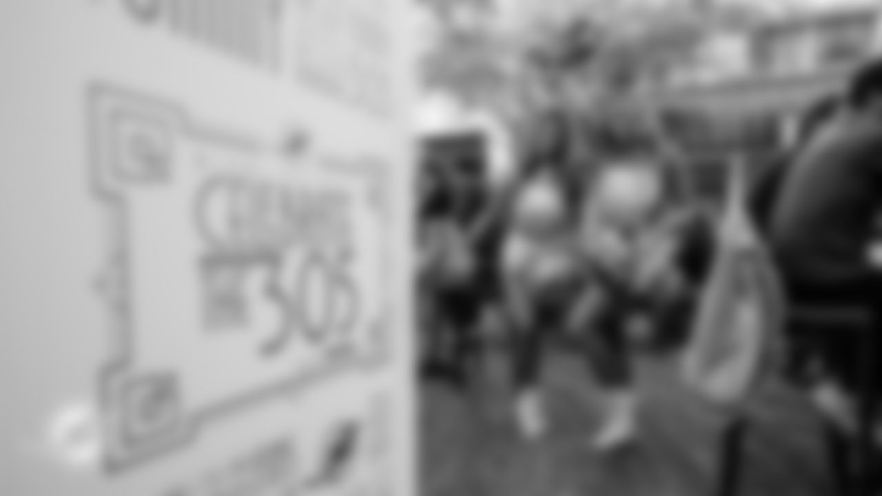 Cheerleaders pose next to a Celebrate the 305 sign.