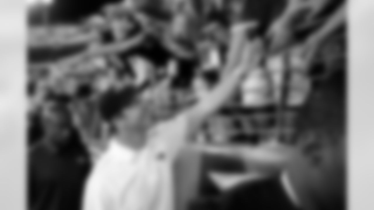 Baltimore Ravens head coach John Harbaugh high-fives fans as he walks off the field after an NFL football game against the Cincinnati Bengals in Baltimore, Monday, Sept. 10, 2012. (AP Photo/Nick Wass)