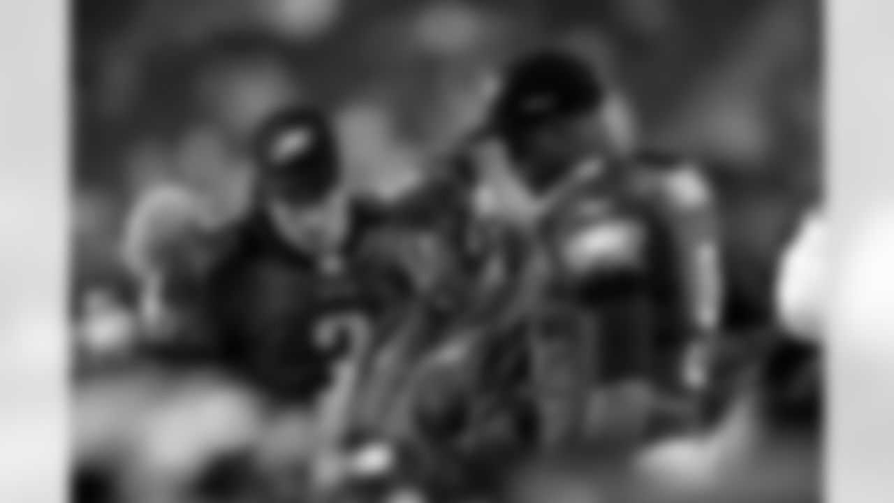 Philadelphia Eagles offensive coordinator Marty Mornhinweg, middle, talks to Vince young, left and Mike Kafka during the second half of an NFL football game against the New England Patriots Sunday, Nov. 27, 2011 in Philadelphia. The Patriots won 38-20. (AP Photo/Michael Perez)