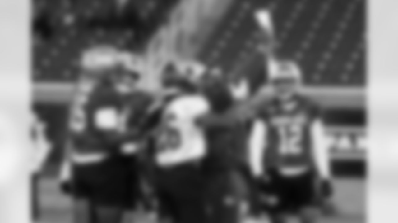 An NFL coach goes over plays with players as they run through drills during practice for the Senior Bowl NCAA college football game Tuesday, Jan. 27, 2026, in Mobile, Ala. (AP Photo/Butch Dill)