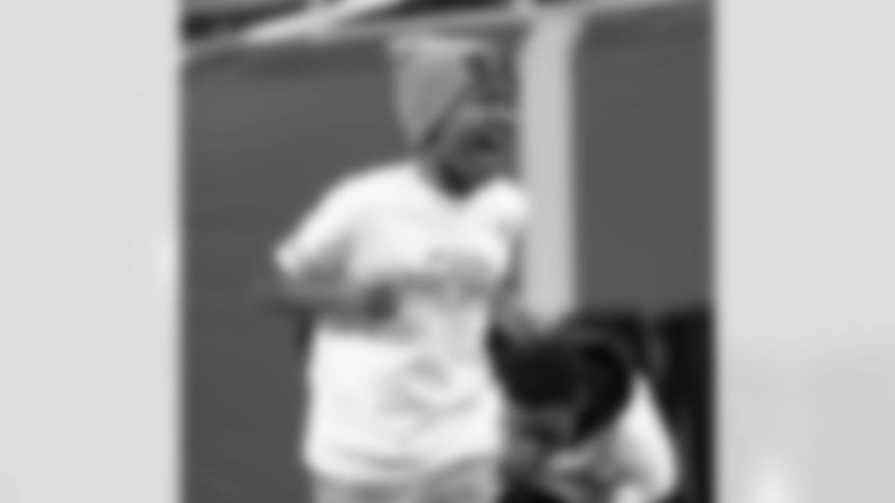 A participant smiling while taking the field during the Inspire Change Football Clinic at Ford Field on Dec. 9, 2025 in Detroit. (Izzy Rincon/Detroit Lions)