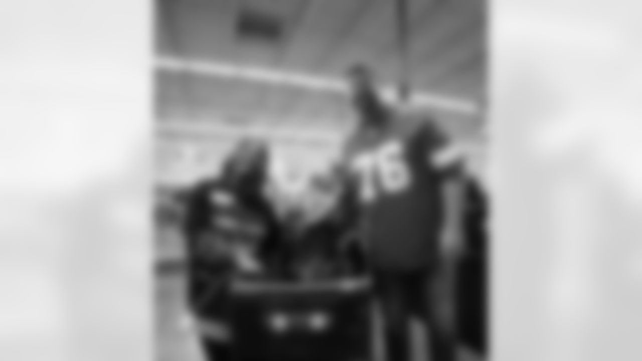 A participant and Lions Legend Jeff Backus (76) pose for a photo during Shop with a Lion at Meijer on Dec. 8, 2025 in Detroit. (Izzy Rincon/Detroit Lions)