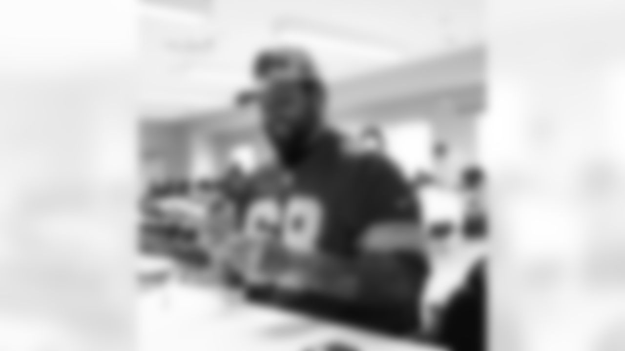 Detroit Lions tackle Taylor Decker (68) signing autographs during a Thanksgiving lunch event at Alternatives For Girls on Nov. 28, 2025 in Detroit. (Izzy Rincon/Detroit Lions)