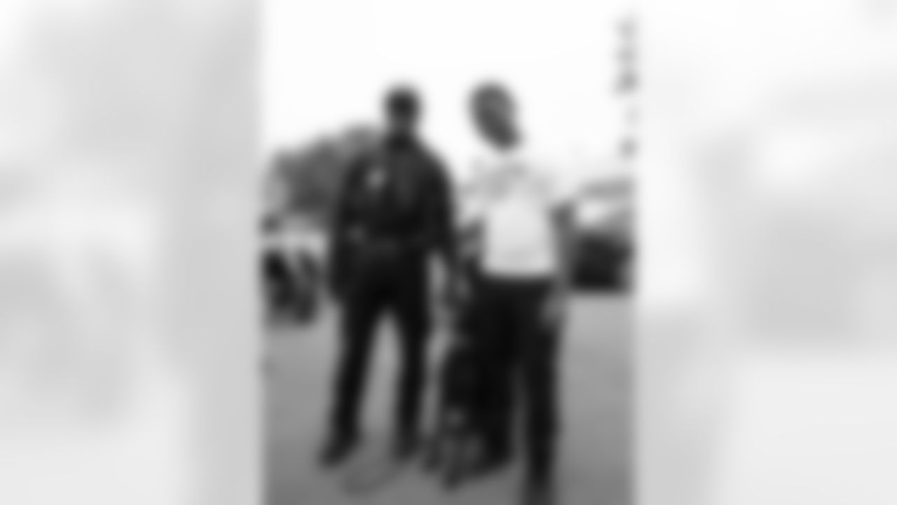 A member of the Detroit Police Department and a student pose for a photo during Field Day at Detroit Lions Academy on June 6, 2025 in Detroit. (Izzy Rincon/Detroit Lions)