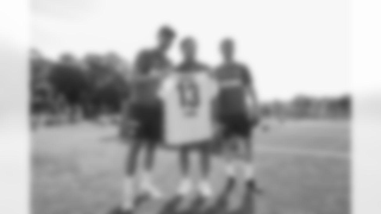 FC Köln goalkeeper Marvin Schwäbe and former FC Köln forward Mark Uth present a jersey to Detroit Lions running back Craig Reynolds (13) at a Detroit Lions youth football camp on June 22, 2025 in Cologne, Germany. (Stuart Zaas/Detroit Lions)