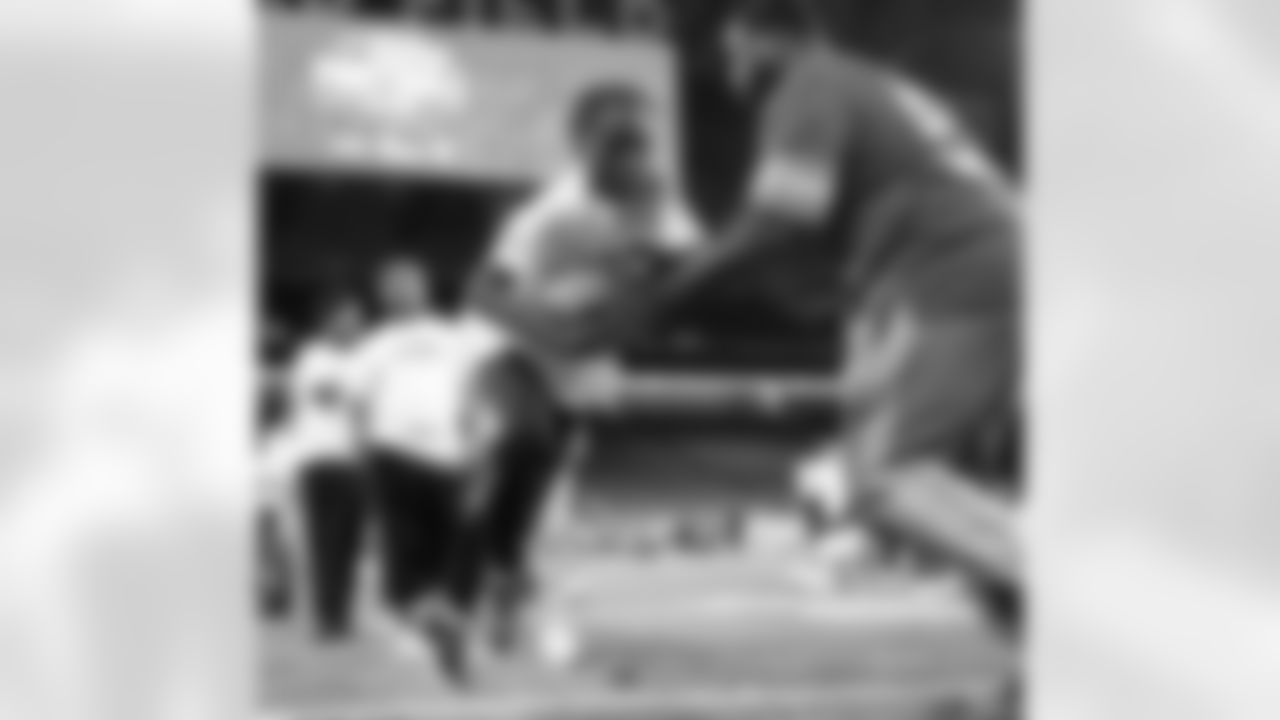 A participant completing a drill with Lions Legend Alex Lewis (59) during the Inspire Change Football Clinic at Ford Field on Dec. 9, 2025 in Detroit. (Izzy Rincon/Detroit Lions)