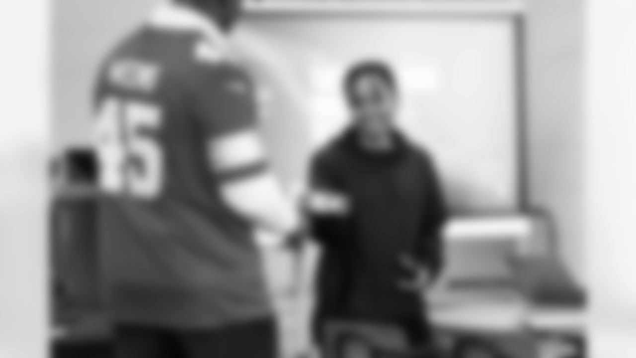 A student receiving a present from Lions Legend Cyrill Weems (45) during the Presents from the Pride event at Detroit Lions Academy on Dec. 16, 2025 in Detroit. (Izzy Rincon/Detroit Lions)