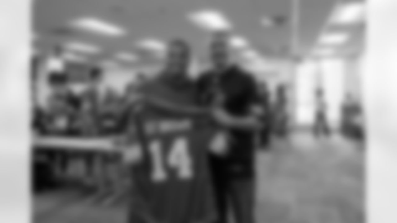 Detroit Lions wide receiver Amon-Ra St. Brown (14) signs a jersey for East Jordan Shoe Club Founder Matt Hamilton after a shoe design competition event at the Meijer Performance Center on Sept. 27, 2025 in Allen Park, Mich. (Carl Jones II/Detroit Lions via AP)