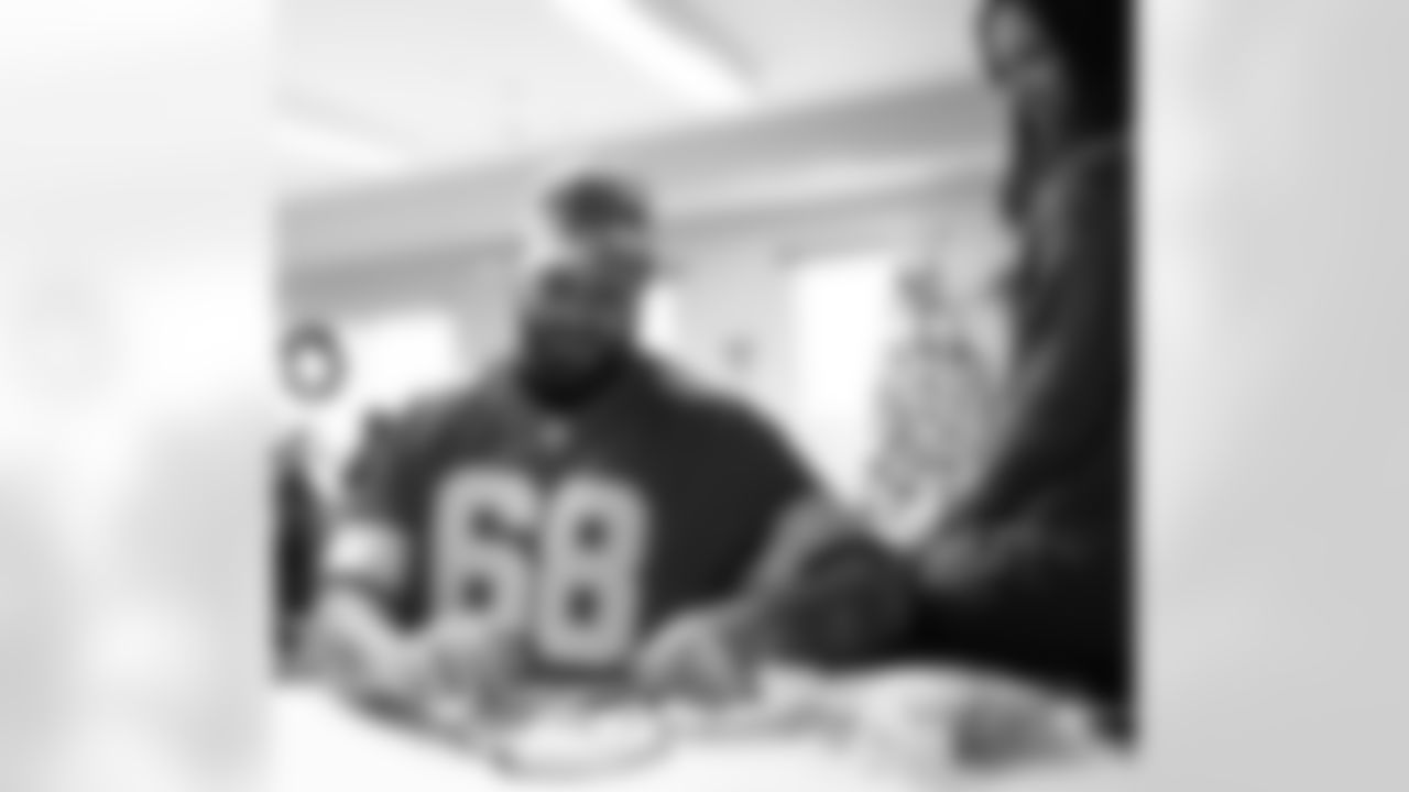 Detroit Lions tackle Taylor Decker (68) signing autographs during a Thanksgiving lunch event at Alternatives For Girls on Nov. 28, 2025 in Detroit. (Izzy Rincon/Detroit Lions)