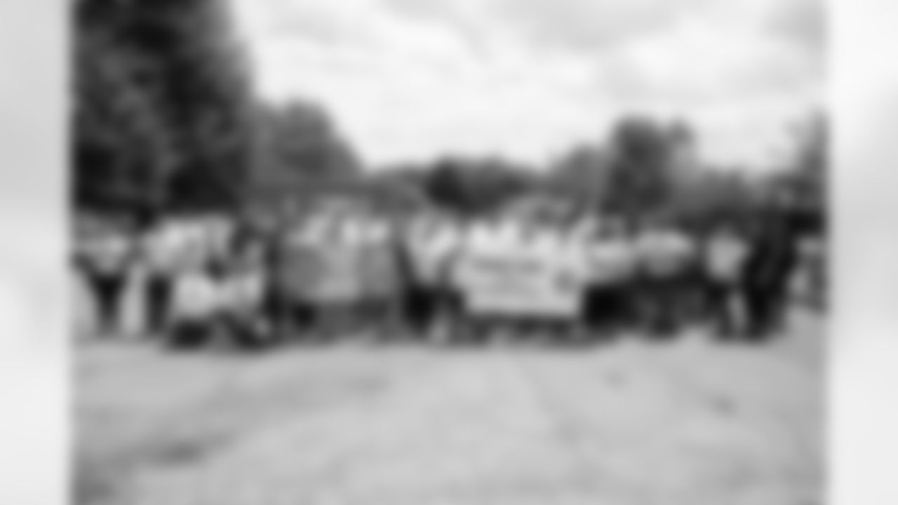 Volunteers take a group photo with thank you banners during a spring cleanup event at the Delray Community Center on June 10, 2025 in Detroit. (Mike Ferdinande/Detroit Lions)