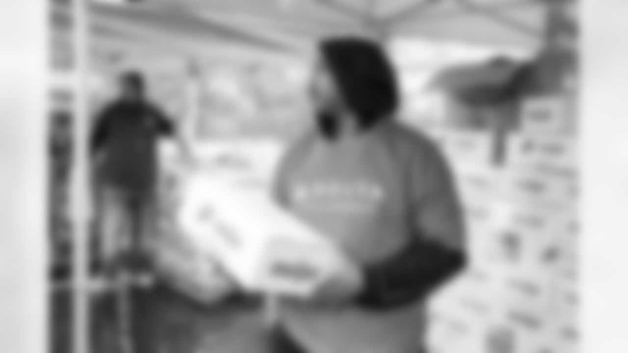 Volunteers load meal kits into cars during a Thanksgiving meal kit distribution event at the Detroit Lions Academy in Detroit, MI on November 20, 2024. (Mike Ferdinande/Detroit Lions)
