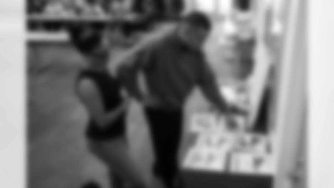 Brooklyn Adams of the St. Brown Foundation and Detroit Lions wide receiver Amon-Ra St. Brown (14) review shoe designs submitted by students during a shoe design competition event at the Meijer Performance Center on Sept. 27, 2025 in Allen Park, Mich. (Carl Jones II/Detroit Lions via AP)